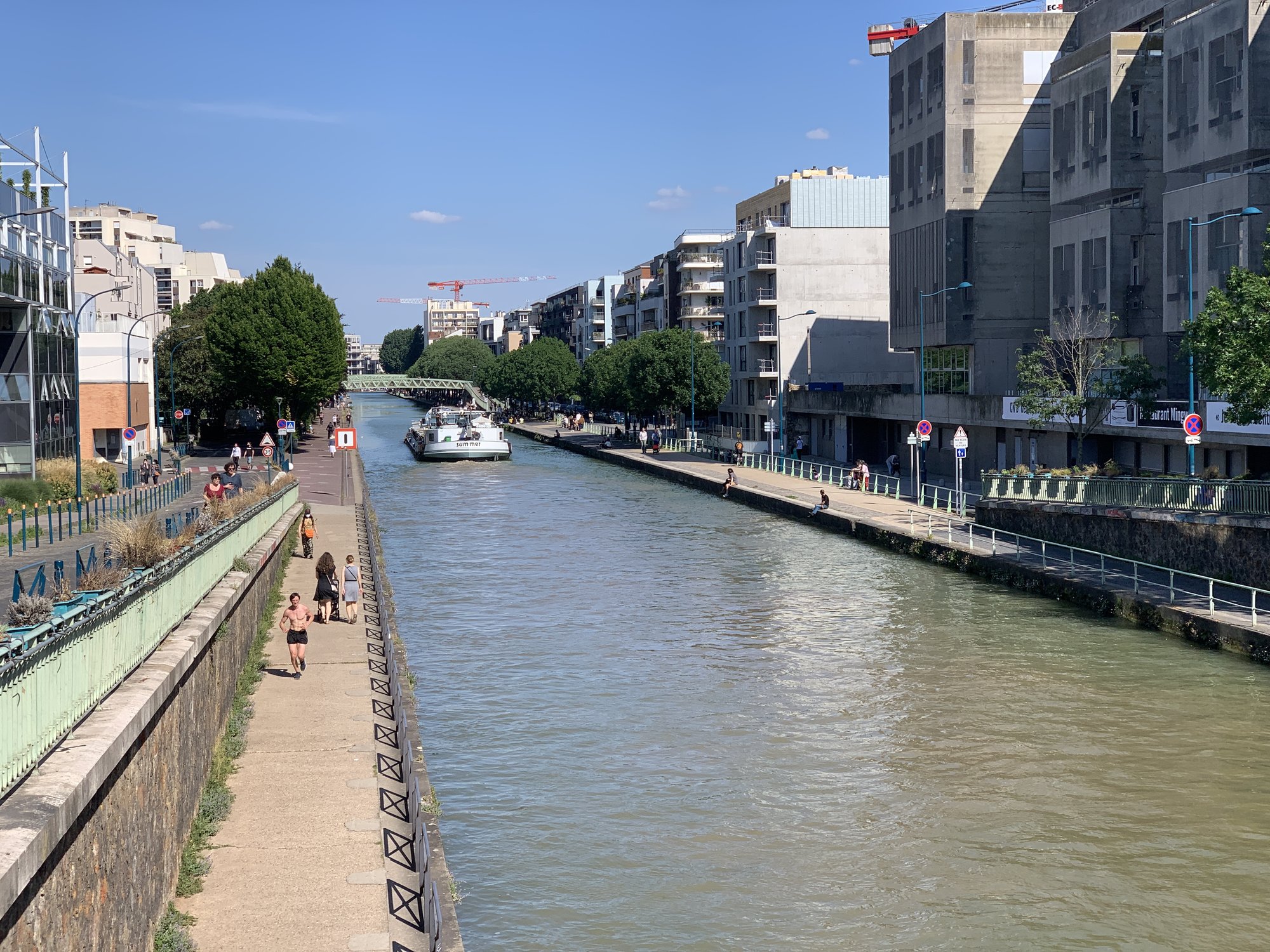 Berges du canal de l'Ourcq avec péniches amarrées et ciel bleu