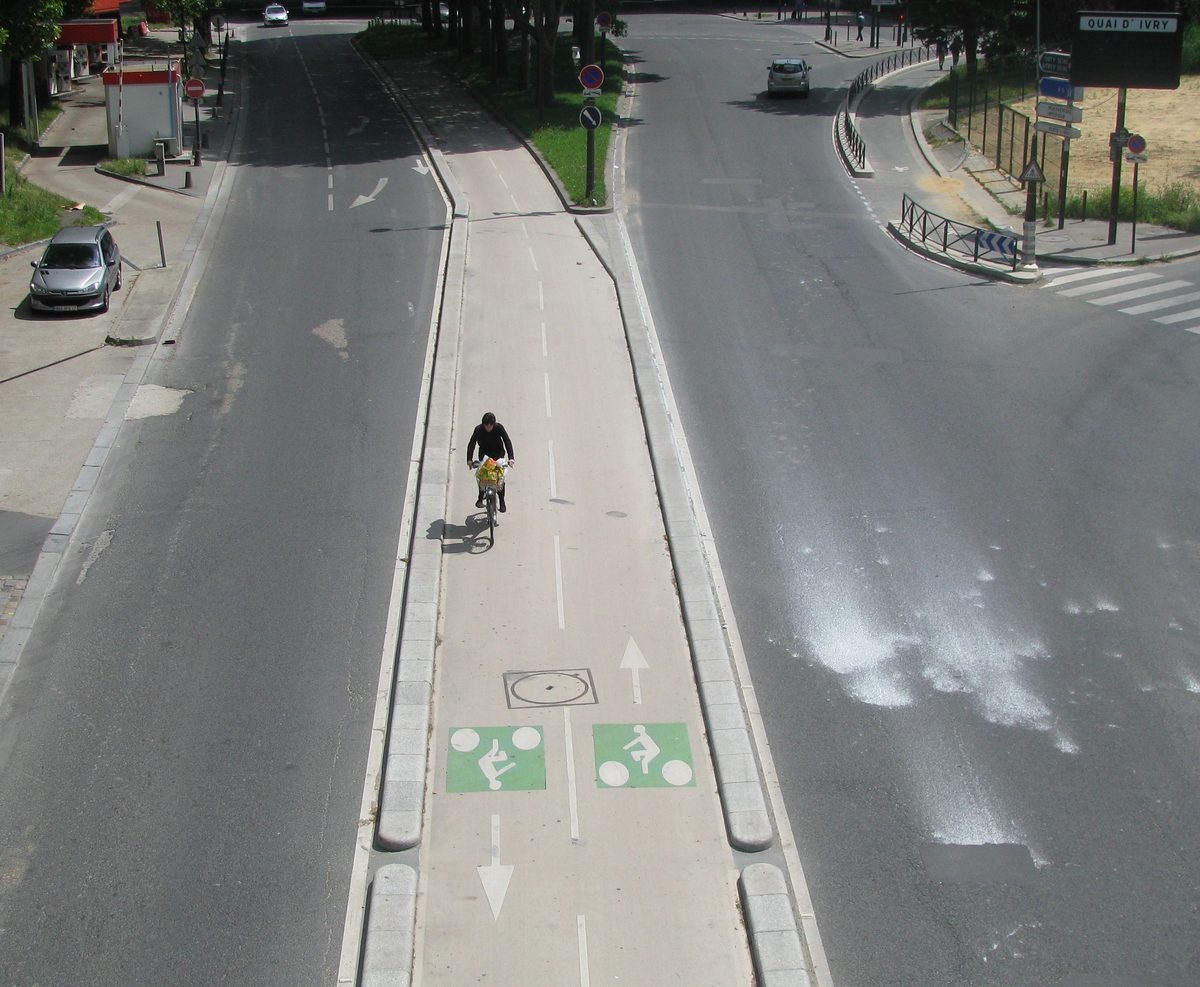 Piste cyclable sécurisée à un carrefour parisien, signalisation vélo